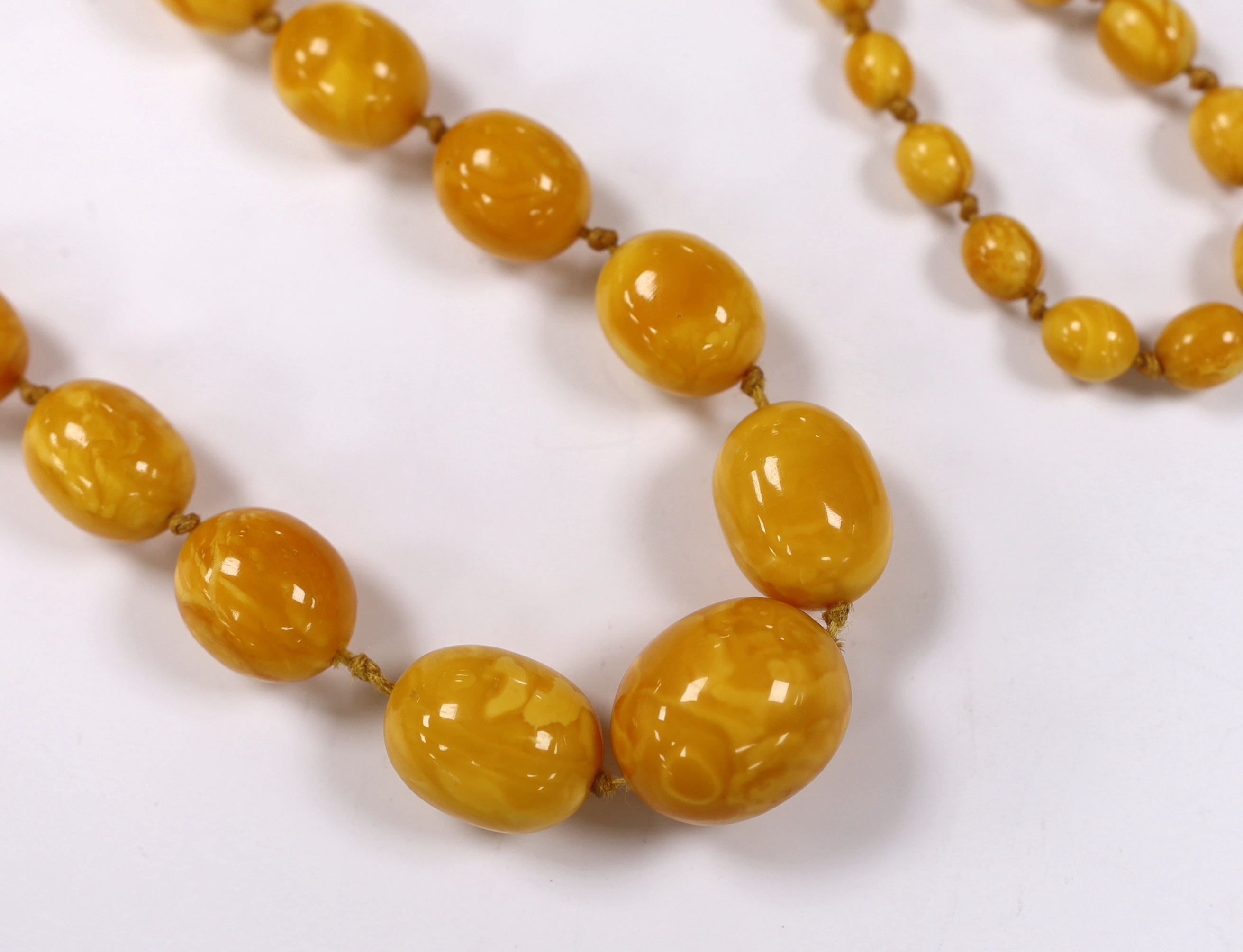 A single strand graduated oval amber bead necklace, 108cm, gross weight 93 grams.